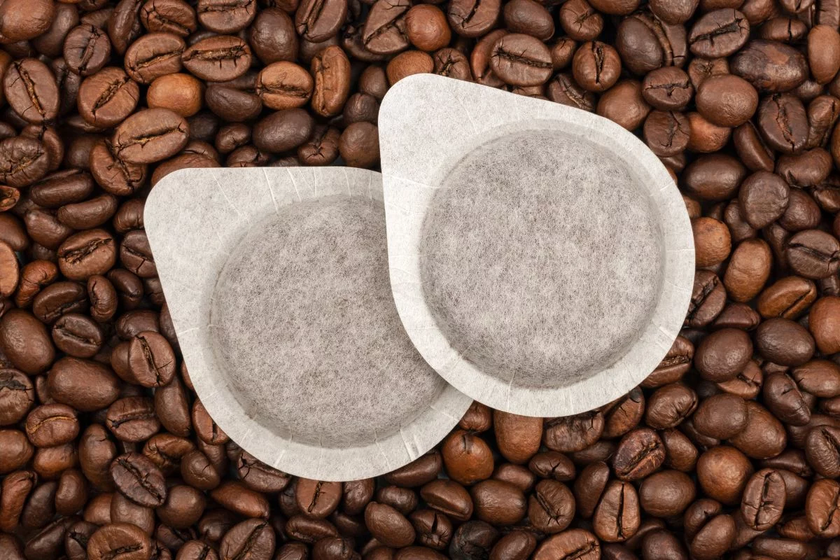 Espresso pad okružen zrnima kafe